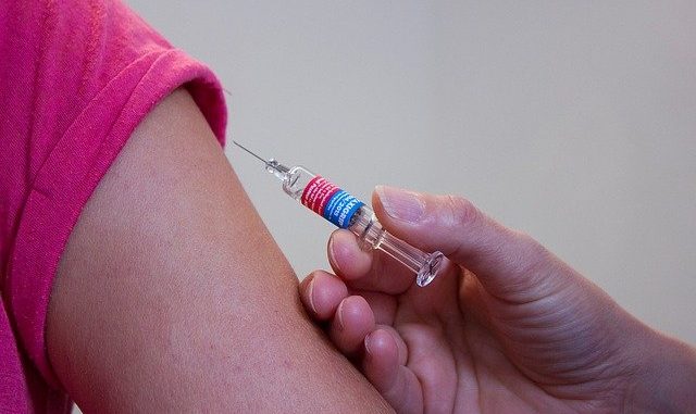 A vaccine being administered via a syringe.