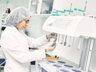 Pharmaceutical scientific female researcher in protective uniform working with dissolution tester at pharmacy industry manufacture factory laboratory Process analytical technology