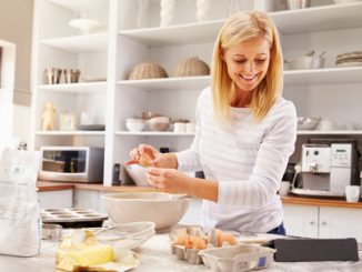 woman baking at home following recipe on a tablet