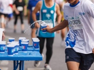 Marathon runners collecting cups of water. They may also contain electrolytes that are lost in sweat.