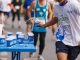 Marathon runners collecting cups of water. They may also contain electrolytes that are lost in sweat.