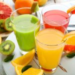 Fresh juices with fruits on wooden table