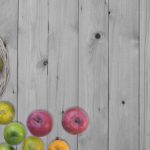Fruits in bottom left hand corner on a grey oak table.