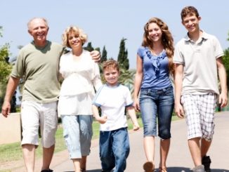 Ant-aging ingredients should be used by all, whatever their age. Family walking arm in arm along a road towards the camera and of all ages.