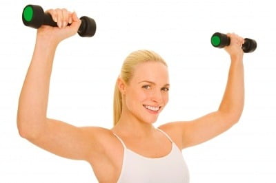 A beautiful woman exercising with dumb bells.