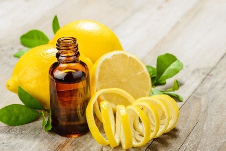 Lemon essential oil and lemon fruit on the wooden board. A place for lemon oils.