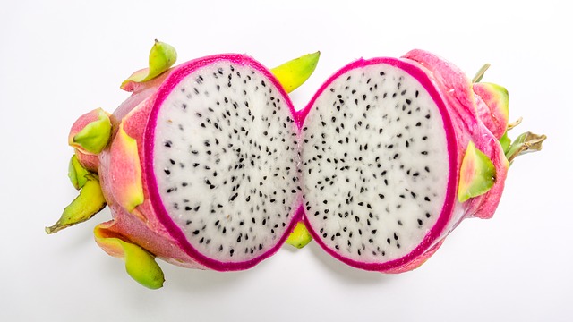 Dragonfruit cut in half to show the white pulp with black seeds.