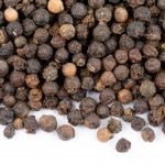 Black peppercorns on a white background.