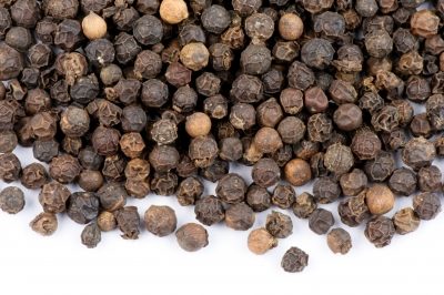 Black peppercorns on a white background.