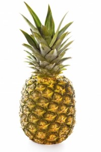 Pineapple, fully ripe and sitting on a white background.