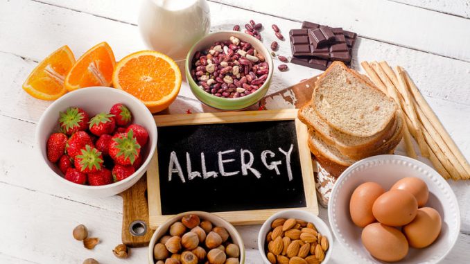 Food allergies. Allergic food on wooden background.