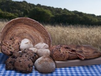 A landscape picture of a basket of baked breads containing quinoa.