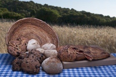 A landscape picture of a basket of baked breads containing quinoa.