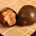 Luo han guo fruit (monk fruit) with bamboo mat on the wooden background