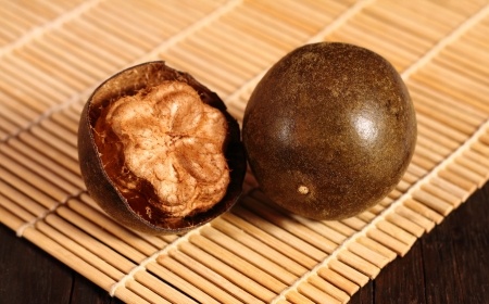 Luo han guo fruit (monk fruit) with bamboo mat on the wooden background