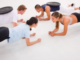 Fit people doing press-ups on the gym floor.. Performance is helped taking beta-alanine supplementation.