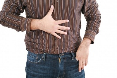 A man feeling the front of his stomach.