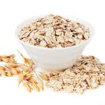 Rolled oats in a plate isolated on white background
