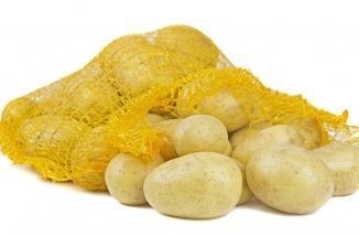 White potatoes in a yellow string bag on a white background.