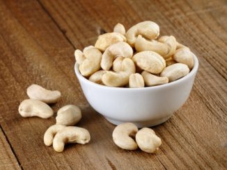 Cashew nuts in bowl on wooden table