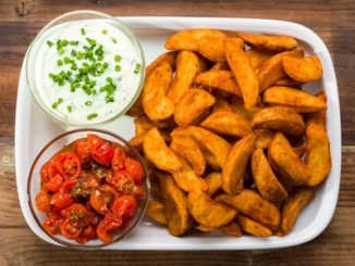 Potato wedges with dip and roasted tomatoes and fresh chives. A potential source of acrylamide.