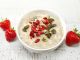 Oat porridge with healthy goji and squash seeds on white wooden table
