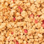 Cereals with red fruit pieces in full picture mode.