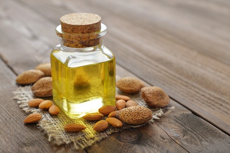 Almond oil in bottle on wooden background