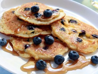 Blueberry pancake with maple syrup on a white plate