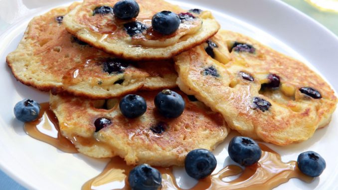 Blueberry pancake with maple syrup on a white plate