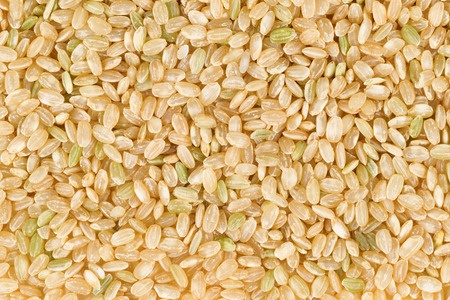 Filled frame of organic raw brown rice in horizontal format.