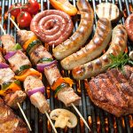 Assorted delicious grilled meat with vegetable over the coals on a barbecue.