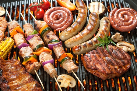 Assorted delicious grilled meat with vegetable over the coals on a barbecue.