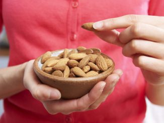 Woman eating healthy snack of almonds