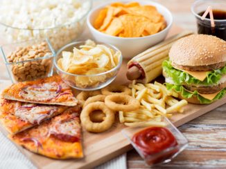 55283534 - fast food and unhealthy eating concept - close up of fast food snacks and cola drink on wooden table