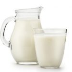 Natural whole milk in a jug and a glass isolated on a white background closeup. A source of milk protein isolate too.