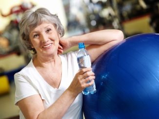 portrait of aged woman with bottle of water by blue ball