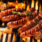 Grilled sausage on the flaming grill