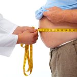 Doctor measuring obese man waist body fat. obesity and weight loss. May be he needs to be on the 5:2 Diet.