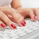 Beautiful nails typing on a keyboard.