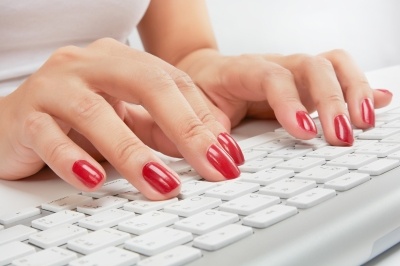 Beautiful nails typing on a keyboard.