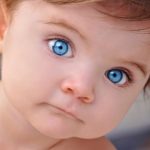 20674889 - a young little baby is looking at the camera with bright blue eyes use it for a child or parenthood concept