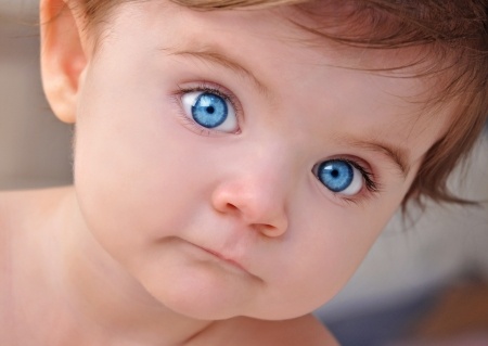 20674889 - a young little baby is looking at the camera with bright blue eyes use it for a child or parenthood concept