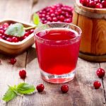 47600813 - glass of cranberry juice with fresh berries on wooden table