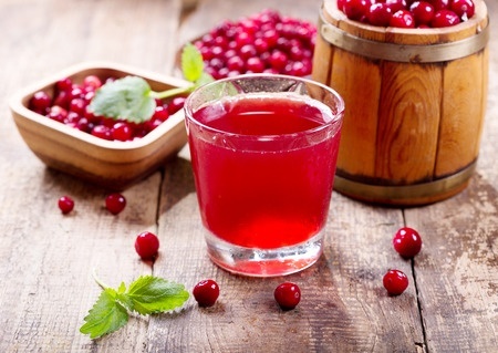 47600813 - glass of cranberry juice with fresh berries on wooden table