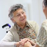 Elderly woman sharing good time with home carer
