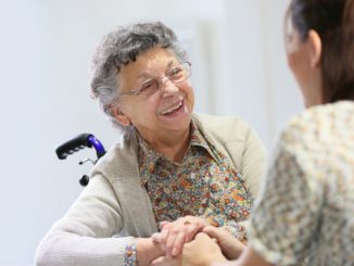 Elderly woman sharing good time with home carer