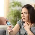 Asthmatic girl suffering an asthma attack receiving an inhaler at home. Vitamin D may reduce severity of attacks.