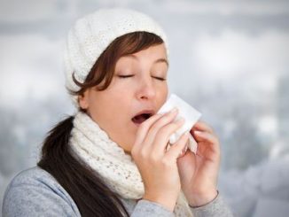 Woman with a cold holding a tissue (without snow in background). Woman taking medicine for coughs, flu and colds