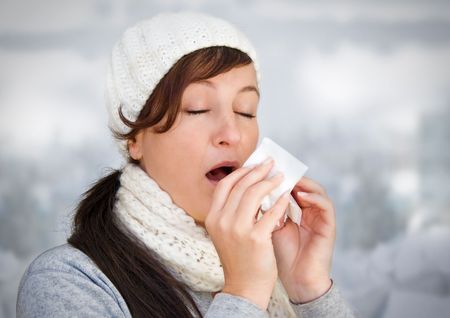 Woman with a cold holding a tissue (without snow in background). Woman taking medicine for coughs, flu and colds
